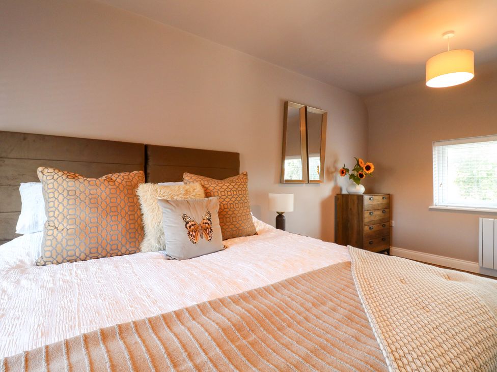 A bedroom with a bed and bedside lamp at 19 Berry Avenue Breedon On The Hill
