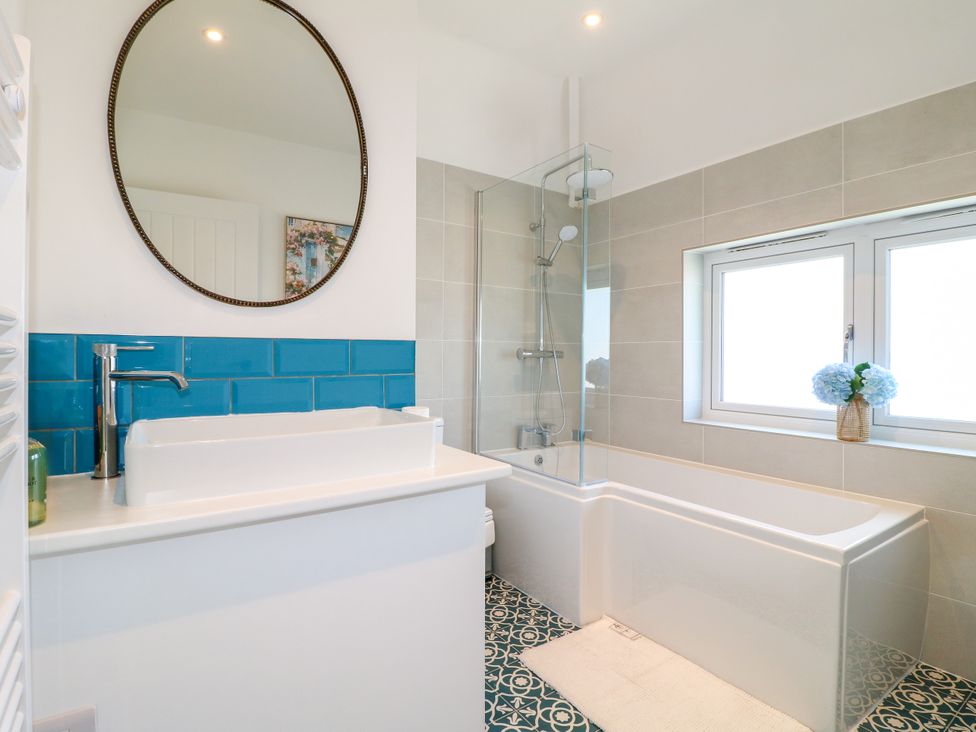 A bathroom with a bathtub and shower at 19 Berry Avenue in Breedon On The Hill