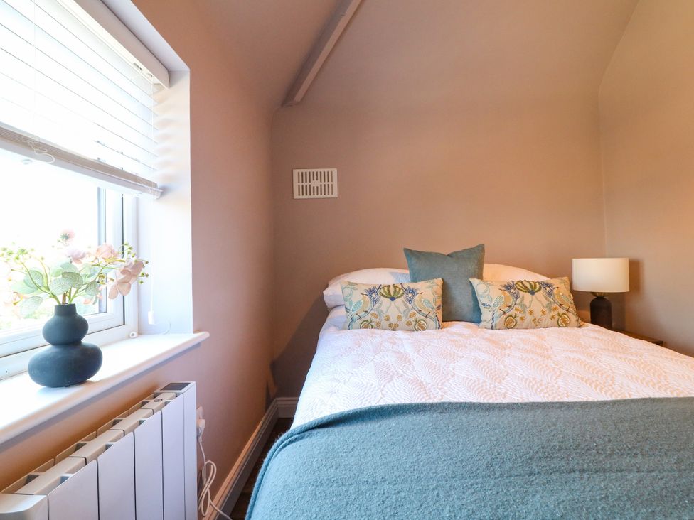 A bedroom with a bed and window at 19 Berry Avenue in Breedon On The Hill