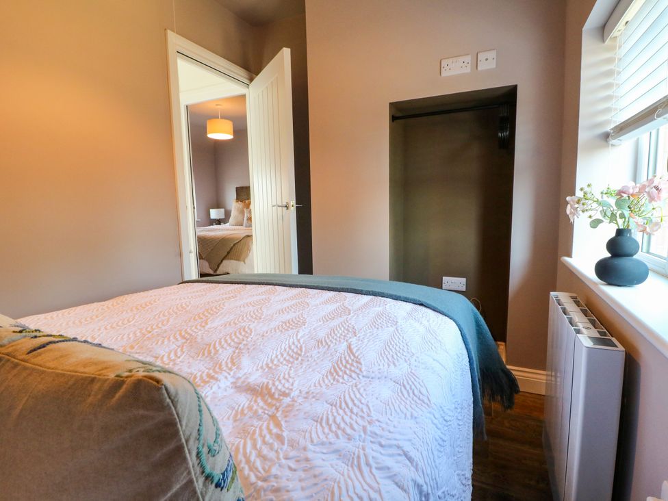 A bedroom with a bed and a door leading to another room at 19 Berry Avenue, Breedon On The Hill