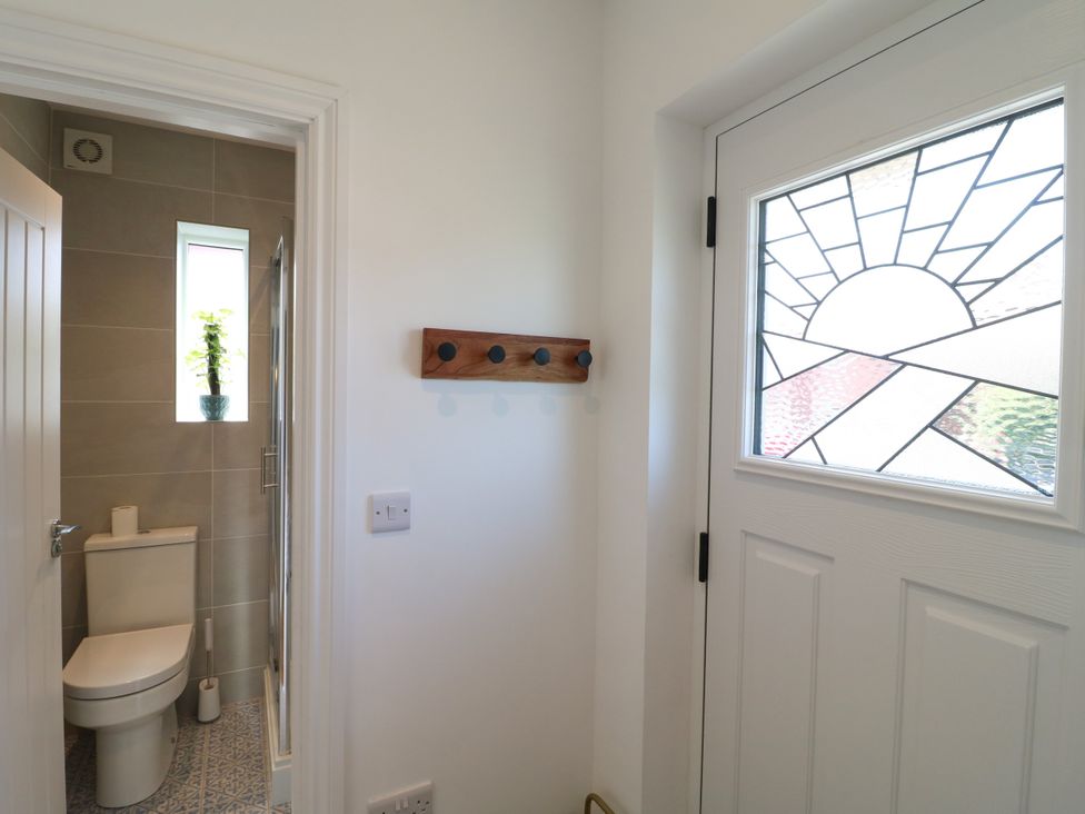 A bathroom with a toilet and shower at 19 Berry Avenue in Breedon On The Hill