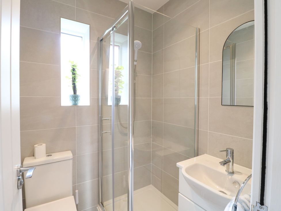 A bathroom with a sink, toilet, and shower at 19 Berry Avenue in Breedon On The Hill