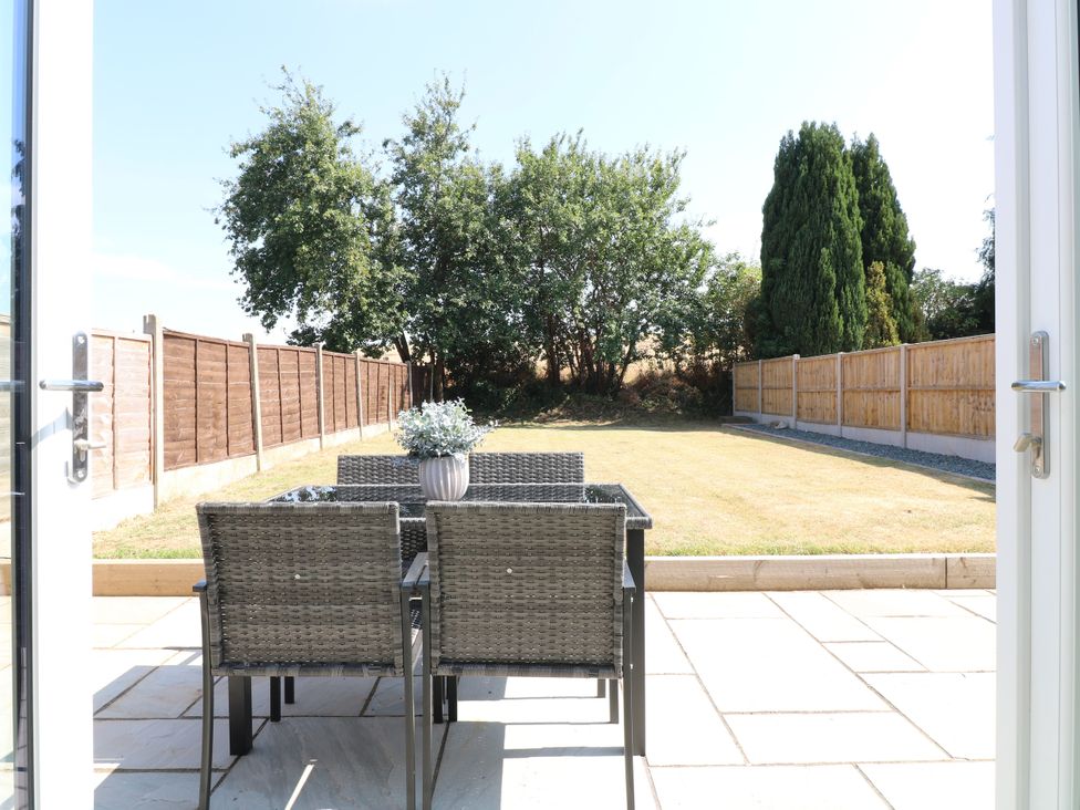 A garden with seating and a view of trees at 19 Berry Avenue in Breedon On The Hill