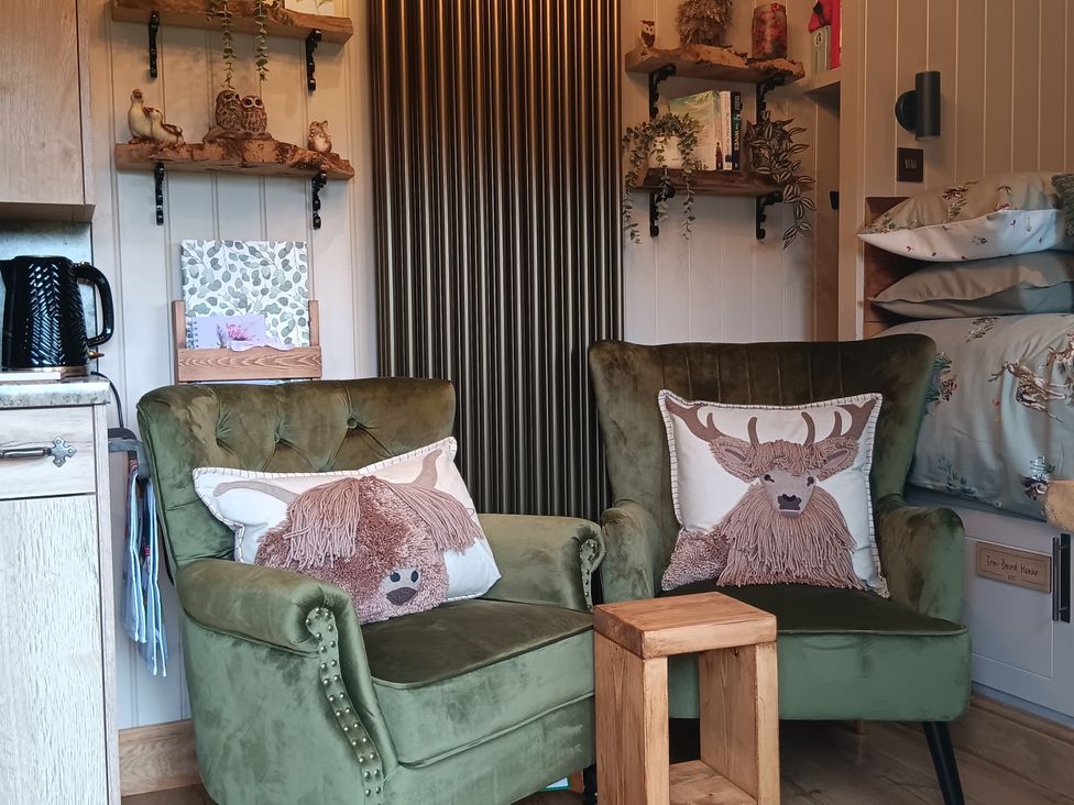 A snug with two armchairs and a table at Twit Twoo Shepherds Hut in North Somercotes
