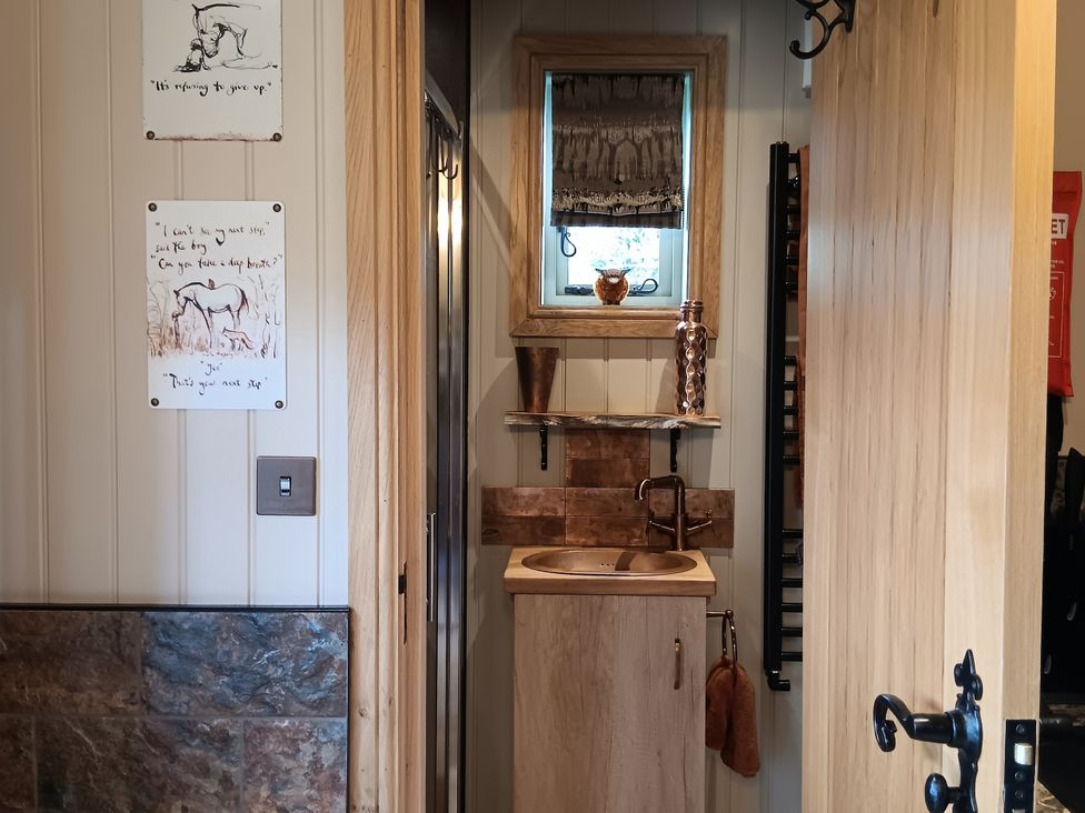 A bathroom with a sink and mirror at Twit Twoo Shepherds Hut North Somercotes