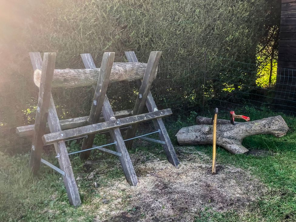 A log splitter and wood logs in an outdoor area at Twit Twoo Shepherds Hut North Somercotes