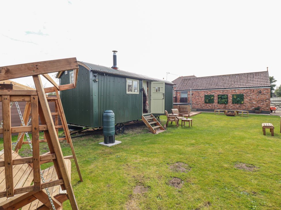 An outdoor area with a shepherd's hut and seating at Twit Twoo Shepherds Hut in North Somercotes