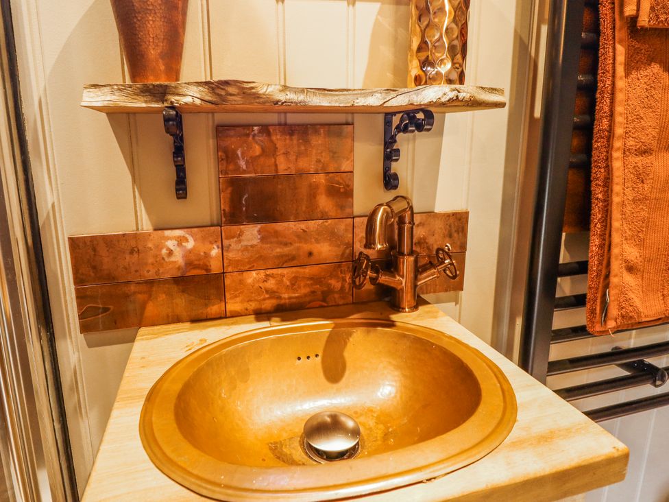 A bathroom with a copper sink and faucet at Twit Twoo Shepherds Hut North Somercotes