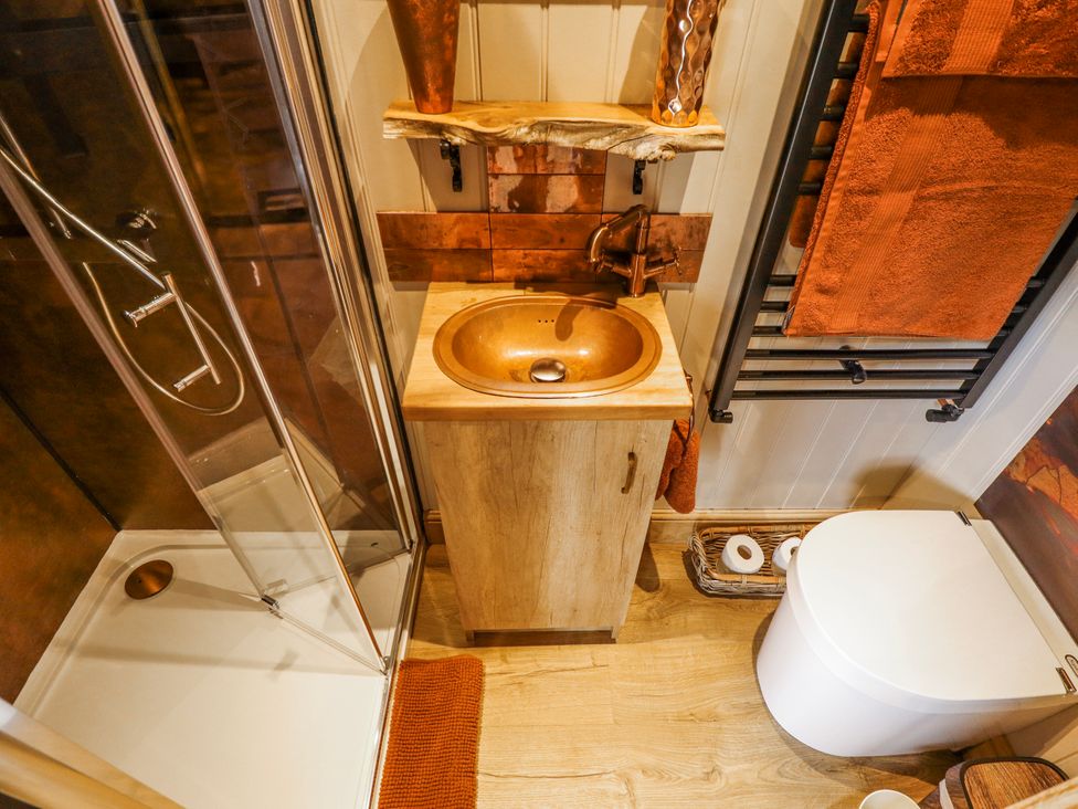 A bathroom with a shower, sink, and toilet at Twit Twoo Shepherds Hut, North Somercotes