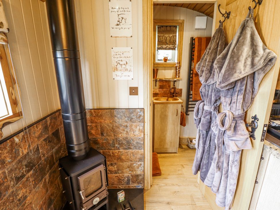 A bathroom with a wood stove and sink at Twit Twoo Shepherds Hut in North Somercotes