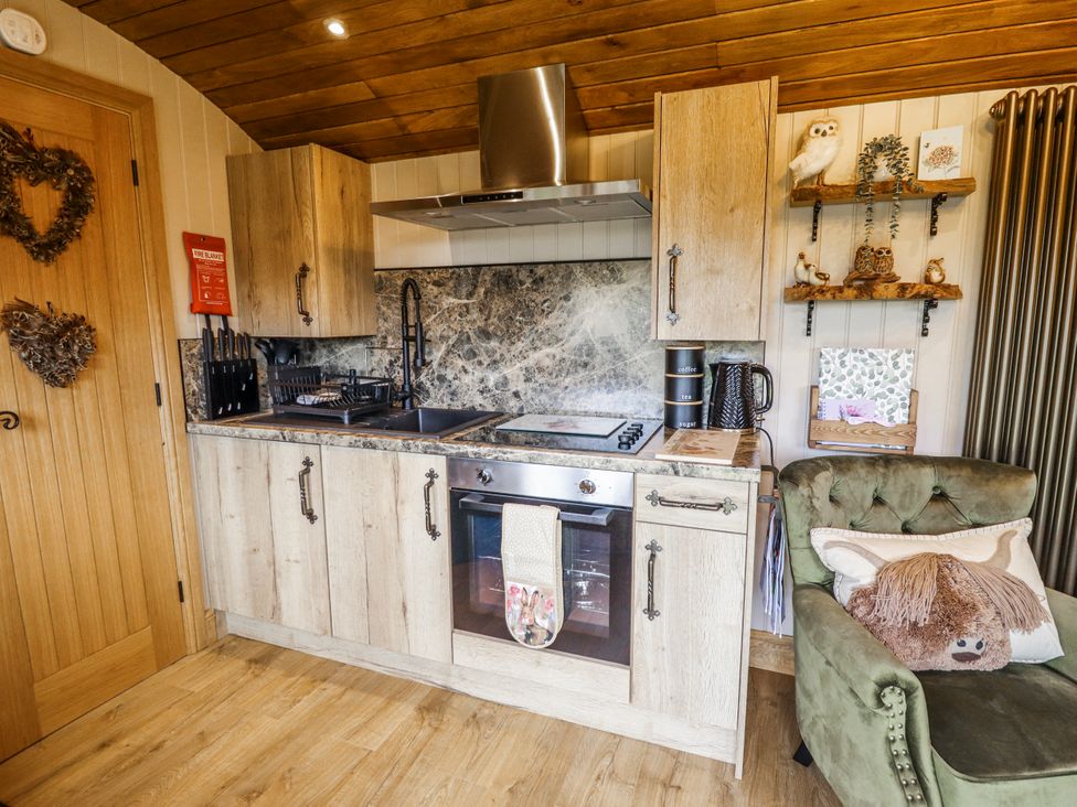 A kitchen with cabinets and appliances at Twit Twoo Shepherds Hut North Somercotes