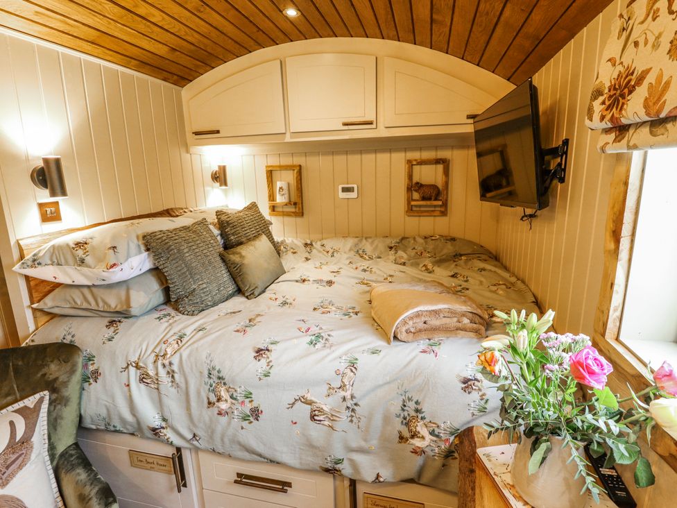 A bedroom with a bed and TV at Twit Twoo Shepherds Hut North Somercotes