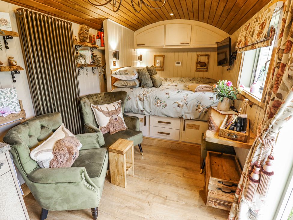 A snug with a bed and armchairs at Twit Twoo Shepherds Hut North Somercotes
