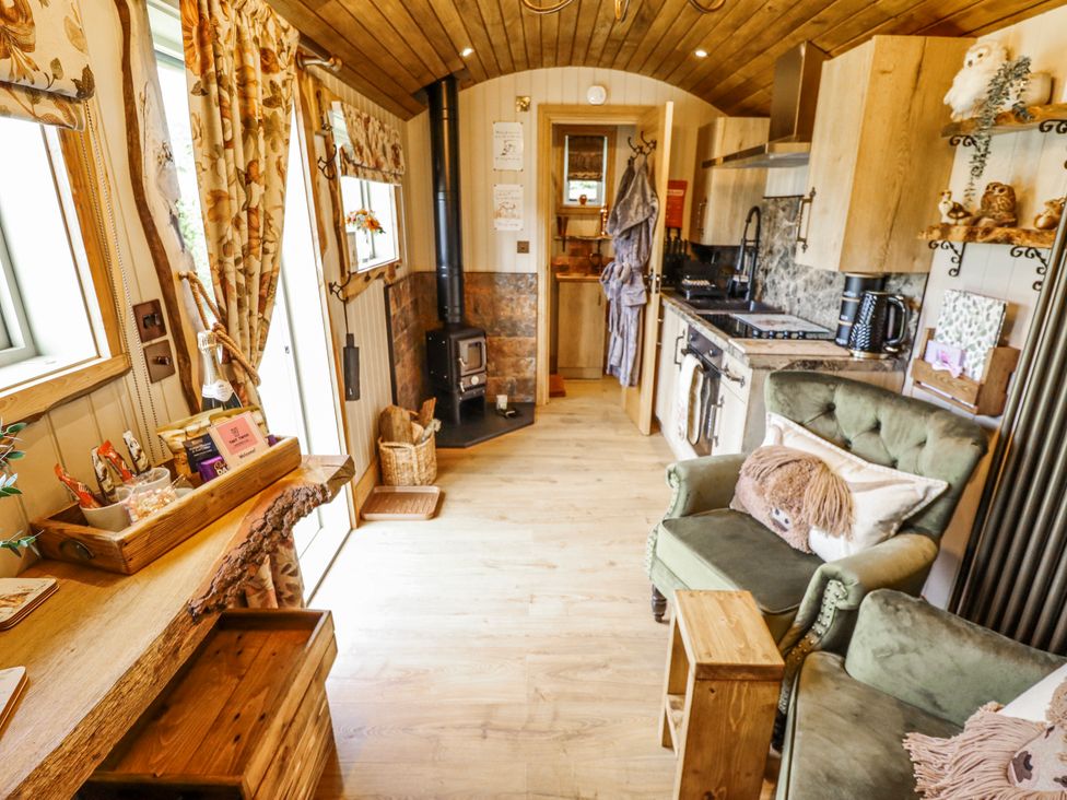 A living room with a sofa and kitchen units at Twit Twoo Shepherds Hut in North Somercotes