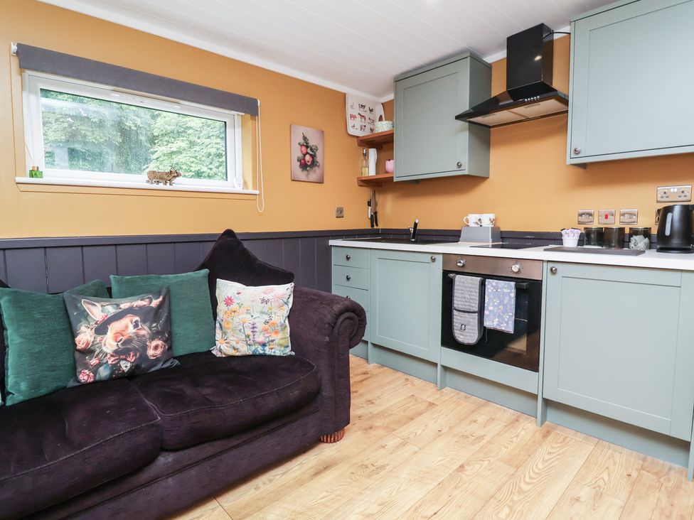 A kitchen with a sofa and cabinets at Owls Nest Lodge South Molton
