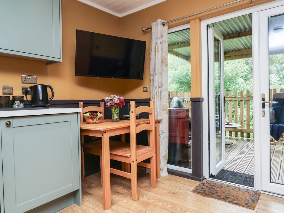 A kitchen with a table and chairs at Owls Nest Lodge South Molton