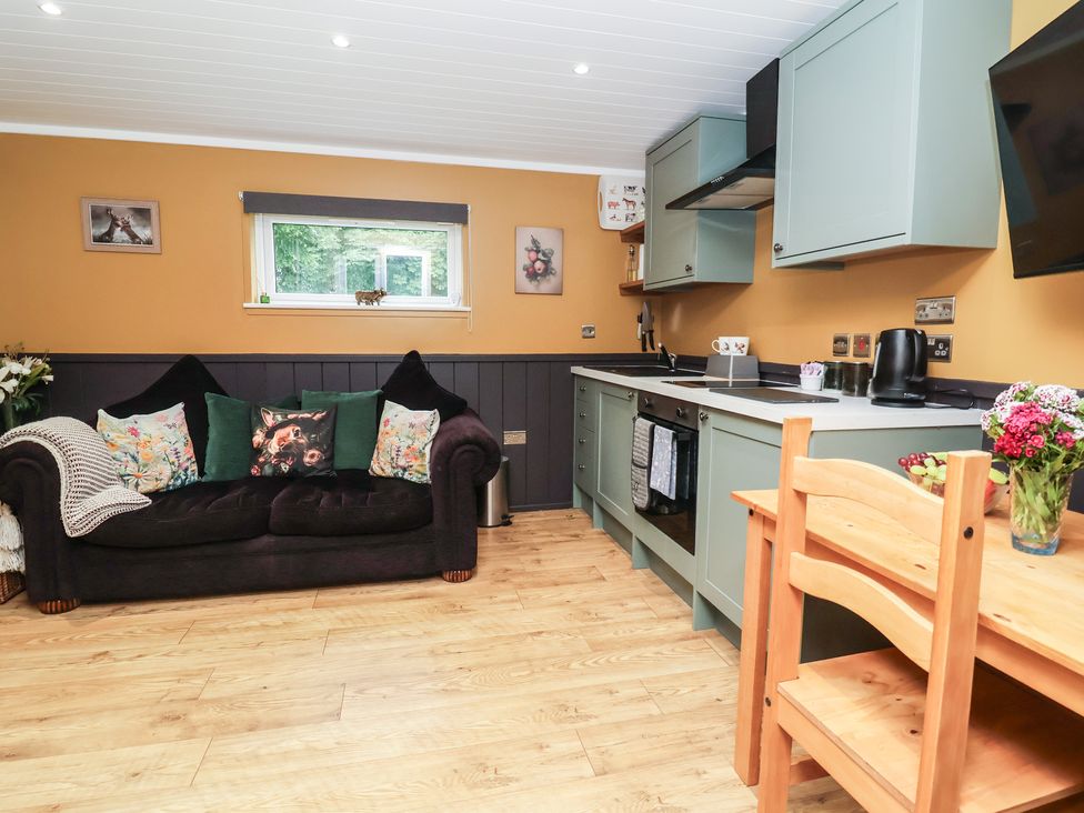 A kitchen with a sofa and dining table at Owls Nest Lodge South Molton