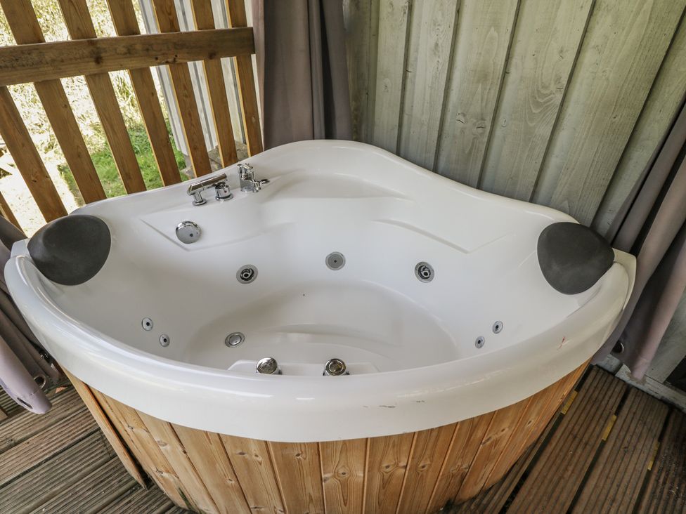A hot tub with a faucet and spout at Owls Nest Lodge South Molton
