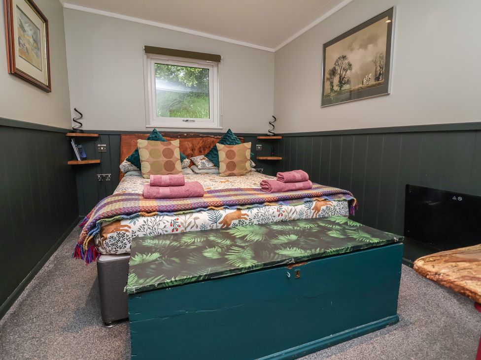 A bedroom with a bed and side tables at Robins Nest Lodge South Molton