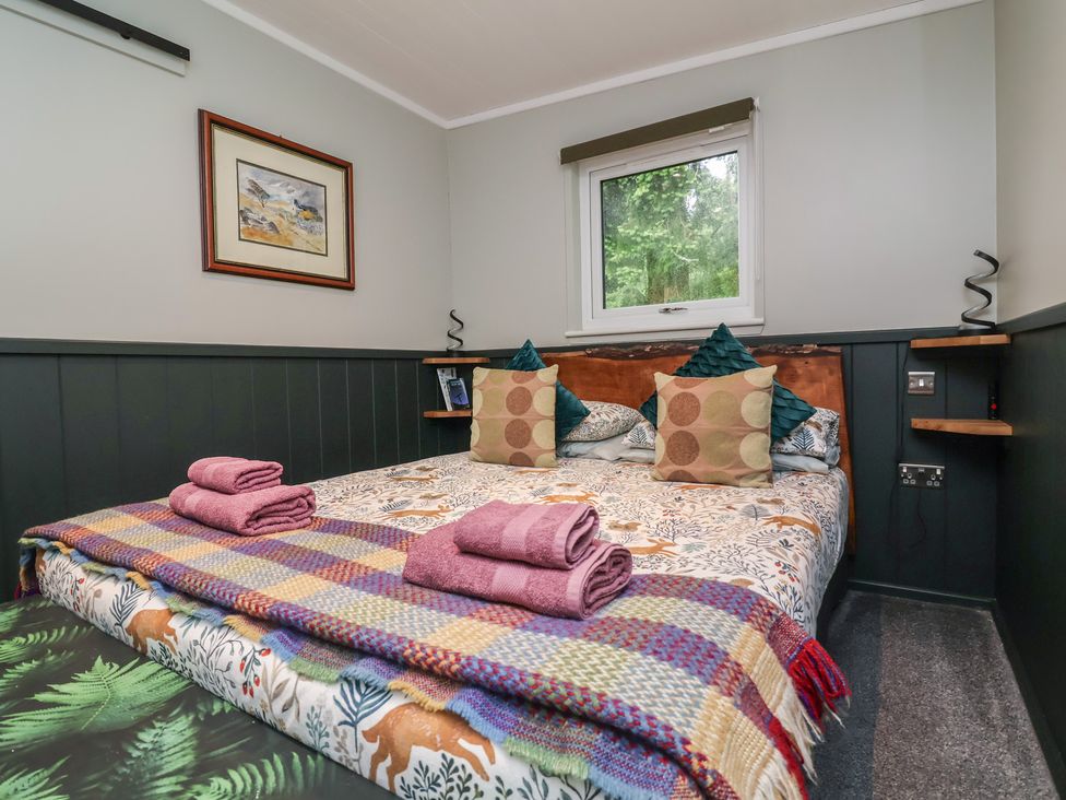 A bedroom with a bed and decorative pillows at Robins Nest Lodge South Molton