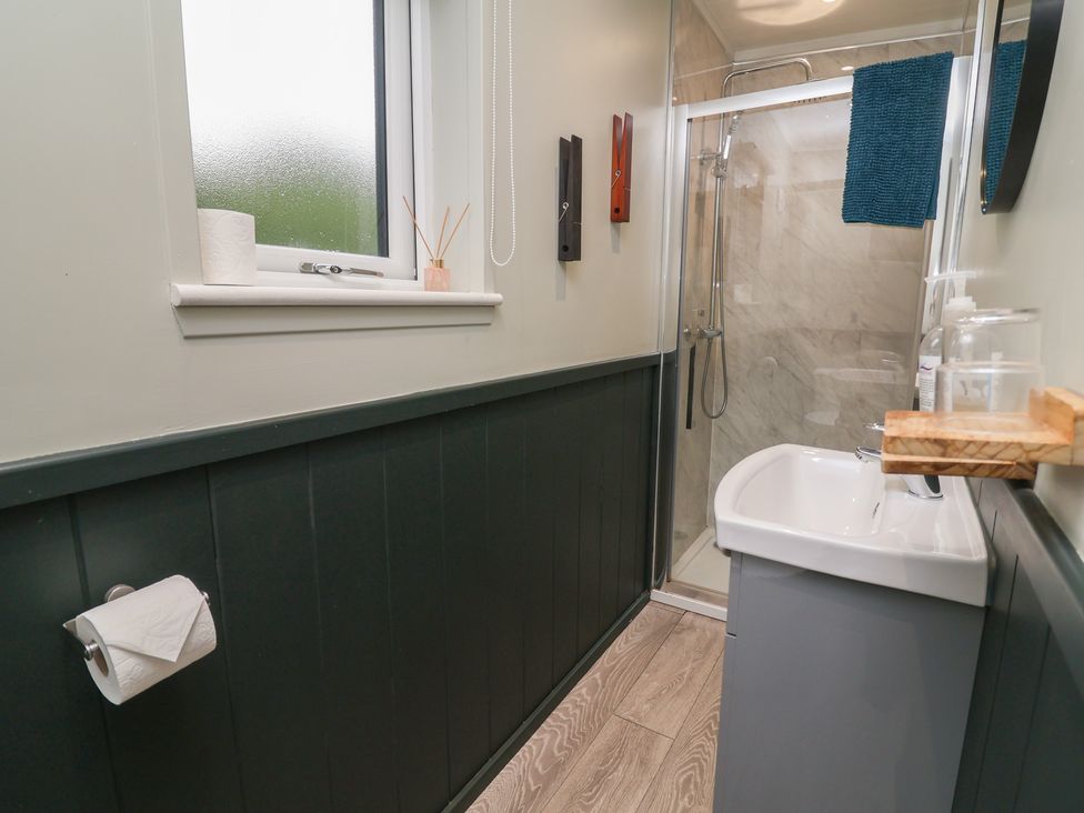A bathroom with a shower and sink at Robins Nest Lodge South Molton