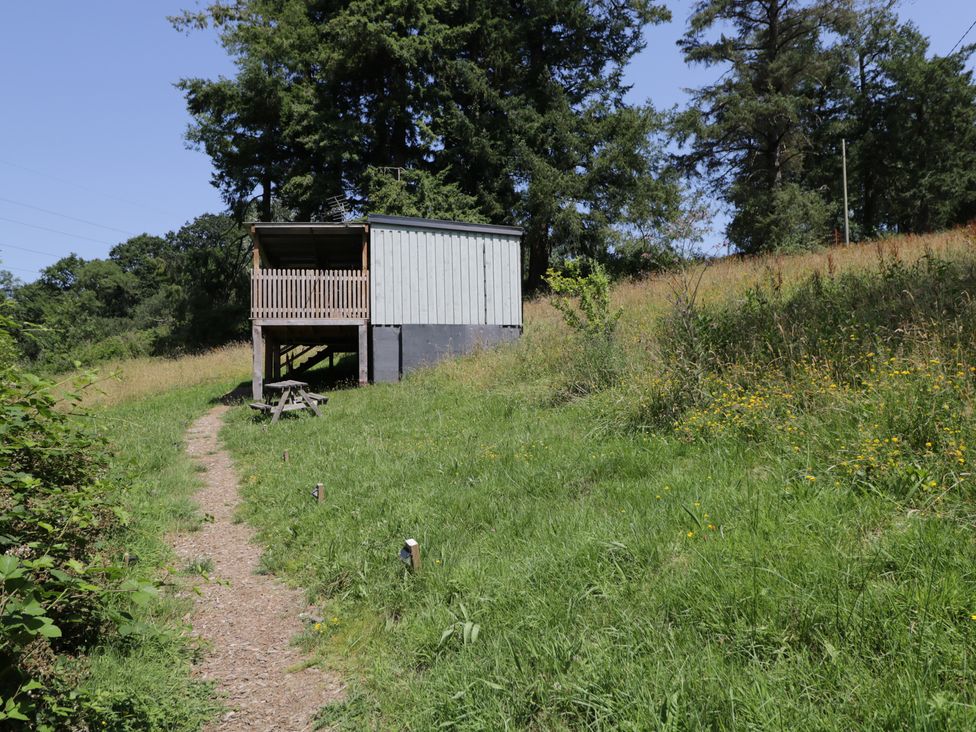 A building with a deck and a path at Robins Nest Lodge South Molton