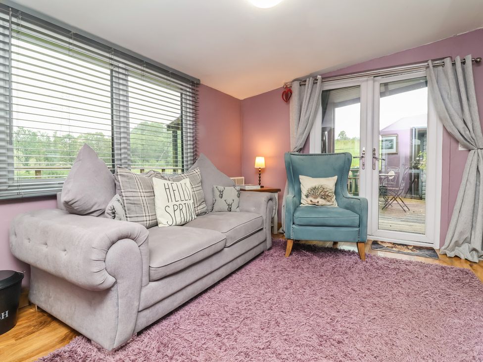 A living room with a sofa and an armchair at Hedgehogs Lodge in South Molton