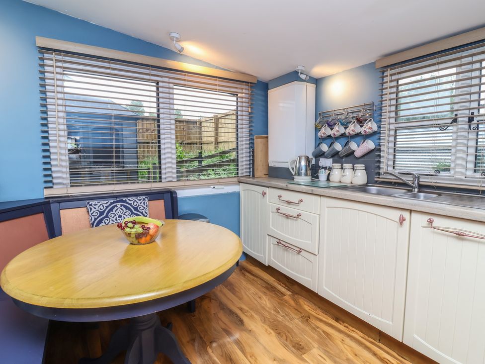 A kitchen with a round table and chairs at Hedgehogs Lodge in South Molton