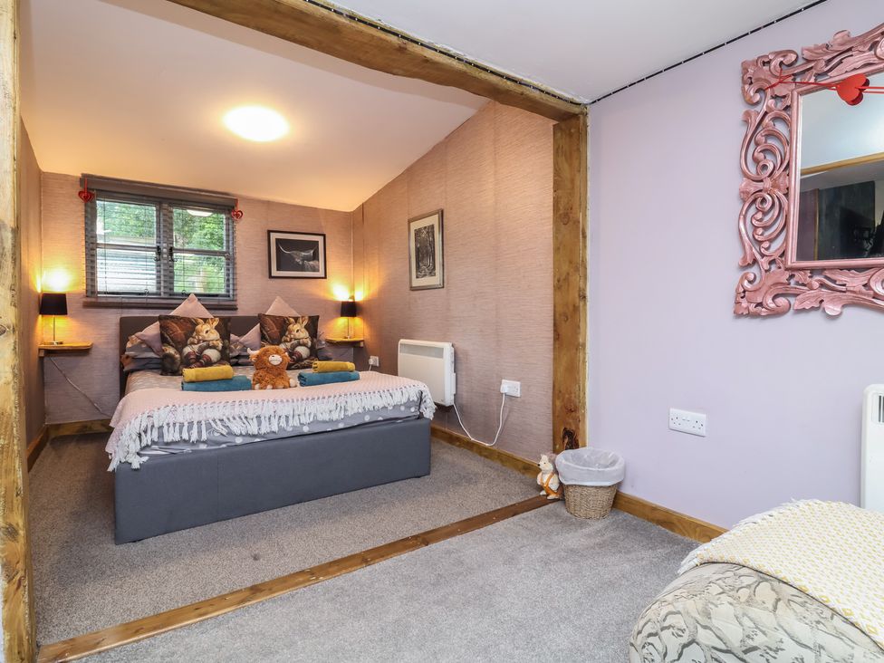 A bedroom with a bed and decorative elements at Hedgehogs Lodge in South Molton