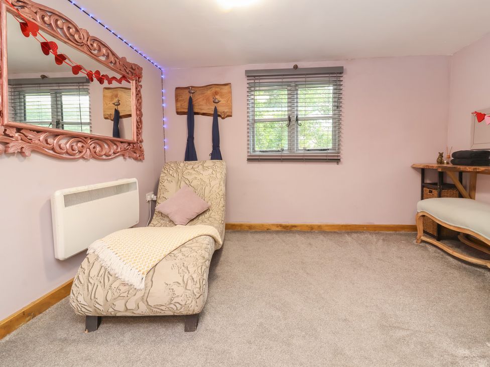 A snug with a chaise longue and a table at Hedgehogs Lodge in South Molton