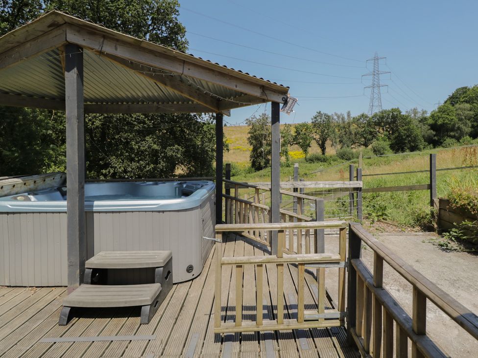 An outdoor area with a hot tub and deck at Hedgehogs Lodge in South Molton