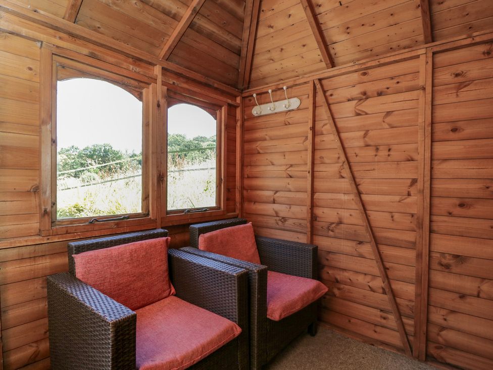 A snug with chairs and windows at Hedgehogs Lodge in South Molton