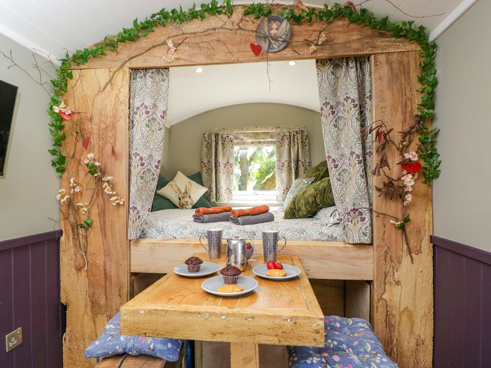 A bedroom with a bed and table in Valley View Shepherd's Hut South Molton