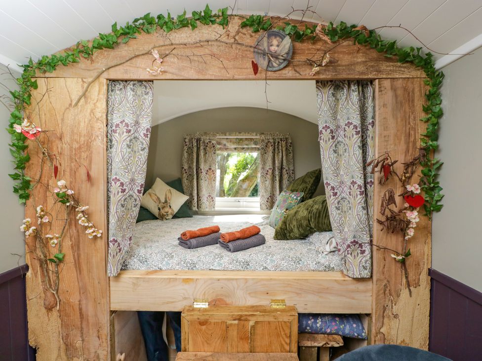 A bedroom with a bed and window at Valley View Shepherd's Hut in South Molton