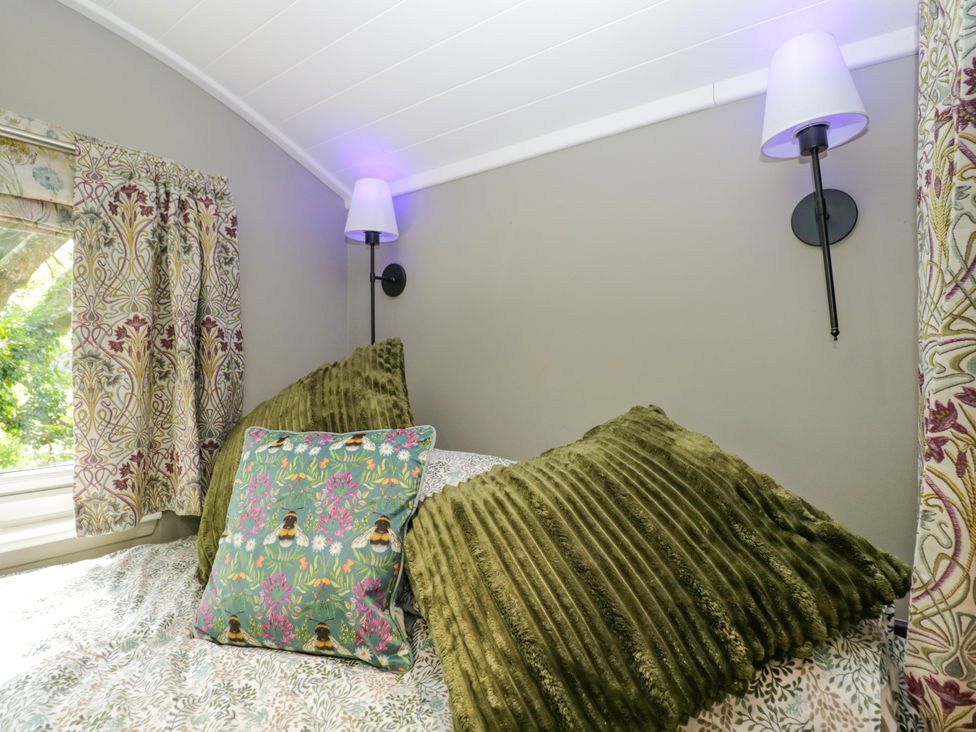 A bedroom with pillows and lamps at Valley View Shepherd's Hut South Molton
