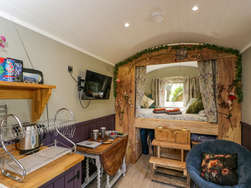 A living room with a bed and kitchenette at Valley View Shepherd's Hut in South Molton