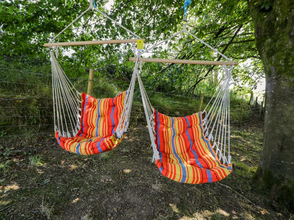 A hammock hanging from a wooden beam in an outdoor area at Valley View Shepherd's Hut South Molton