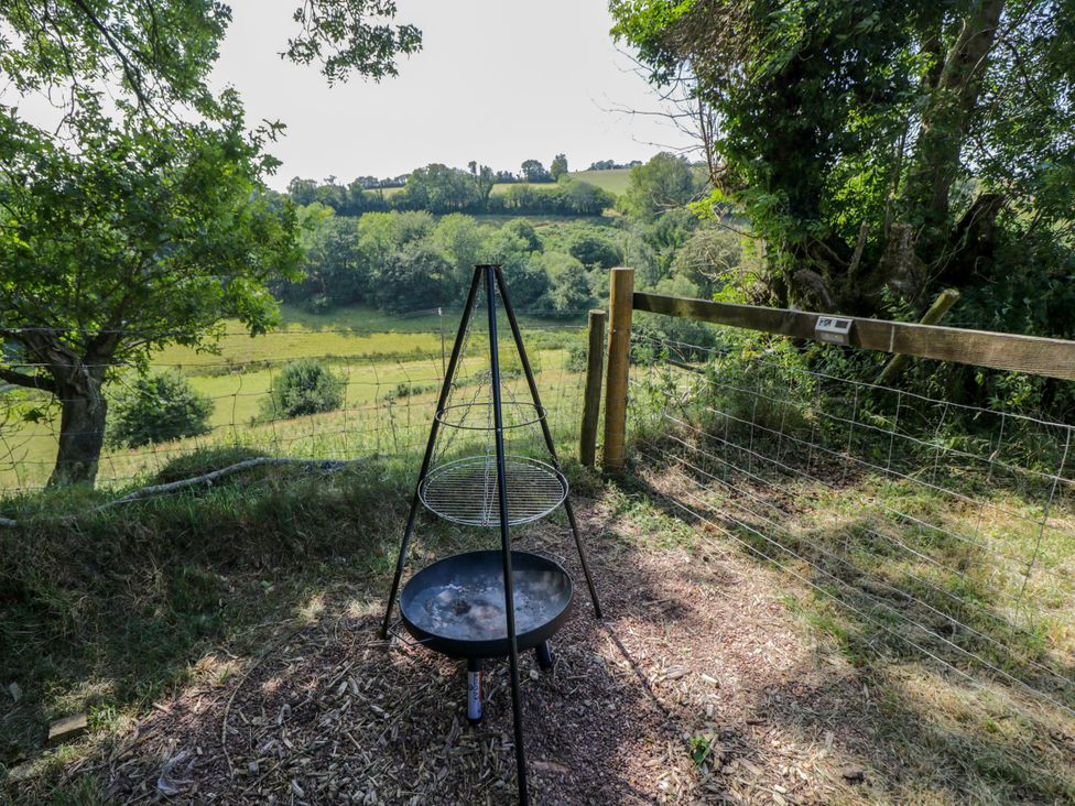 A fire pit with a view of hills at Valley View Shepherd's Hut in South Molton