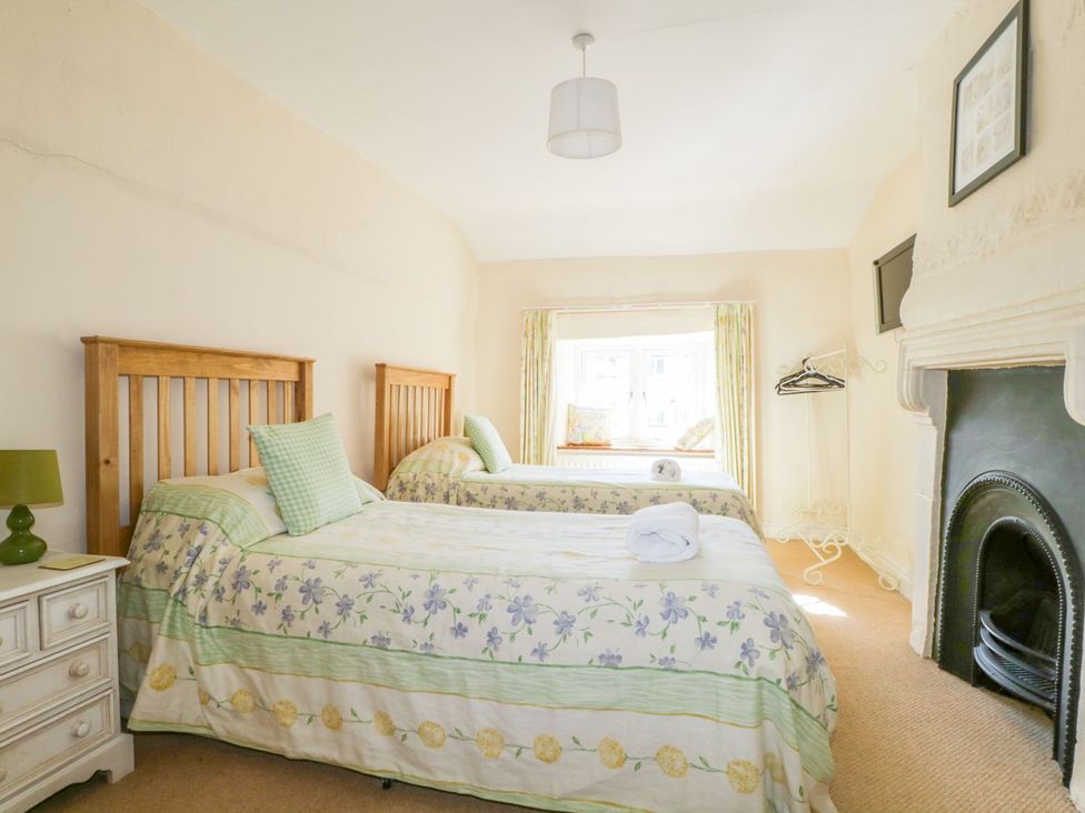 A bedroom with two beds and a window at The Farmhouse in Keswick