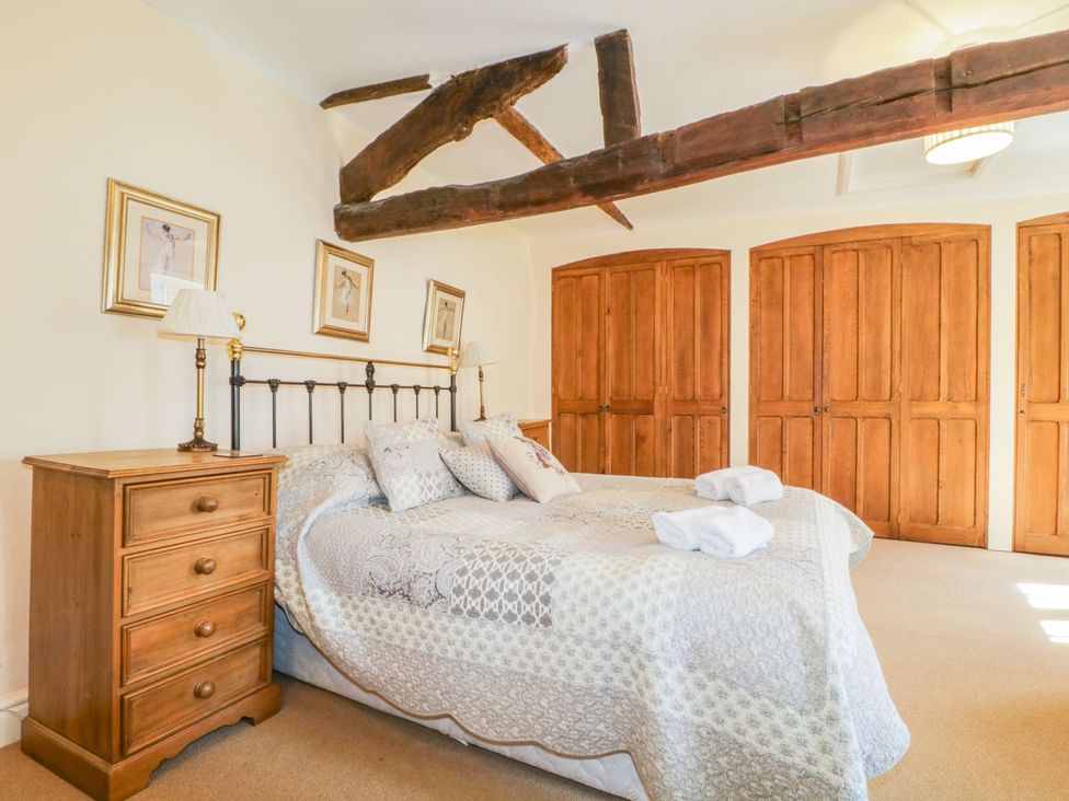 A bedroom with a bed and wardrobe at The Farmhouse in Keswick