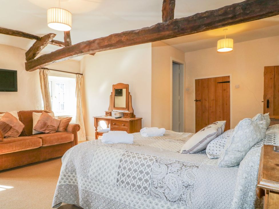 A bedroom with a bed and sofa at The Farmhouse in Keswick