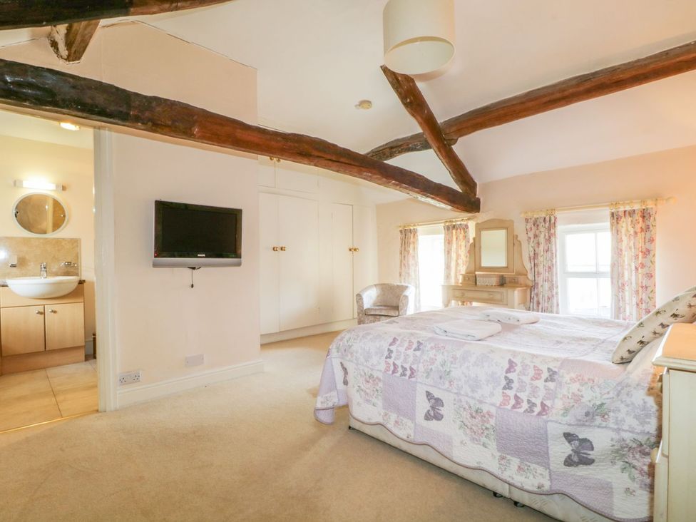 A bedroom with a bed, television, and mirror at The Farmhouse in Keswick