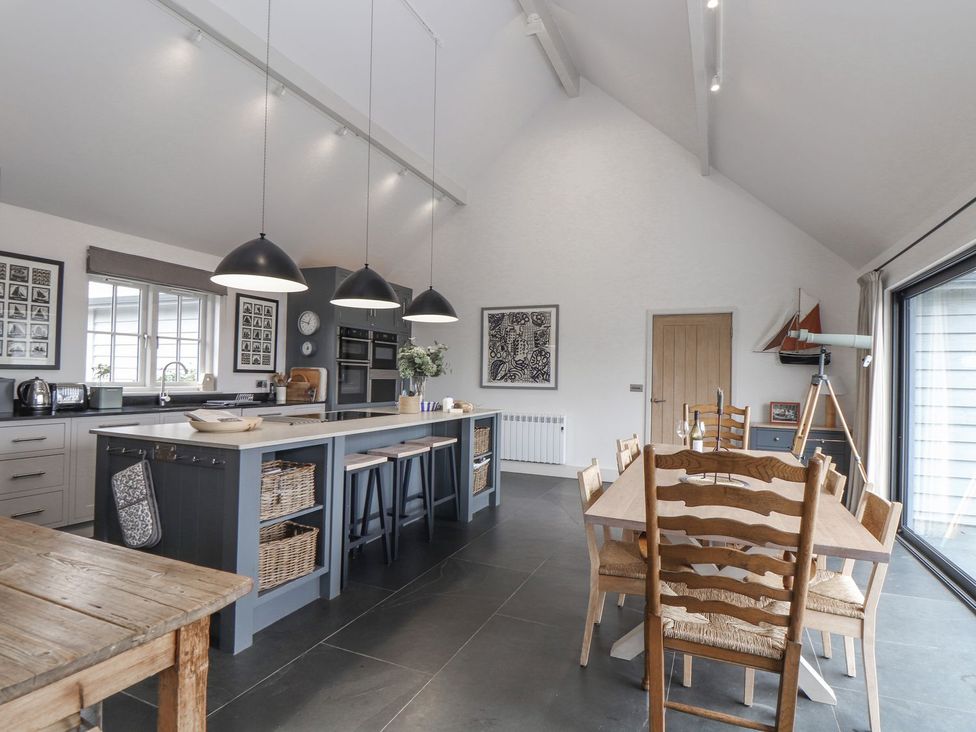 A kitchen with an island and dining area at Wood Meadow in Helston