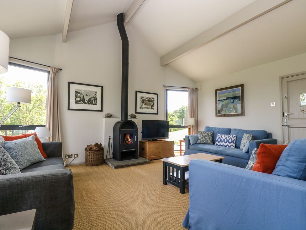 A living room with a fireplace and television at Wood Meadow in Helston