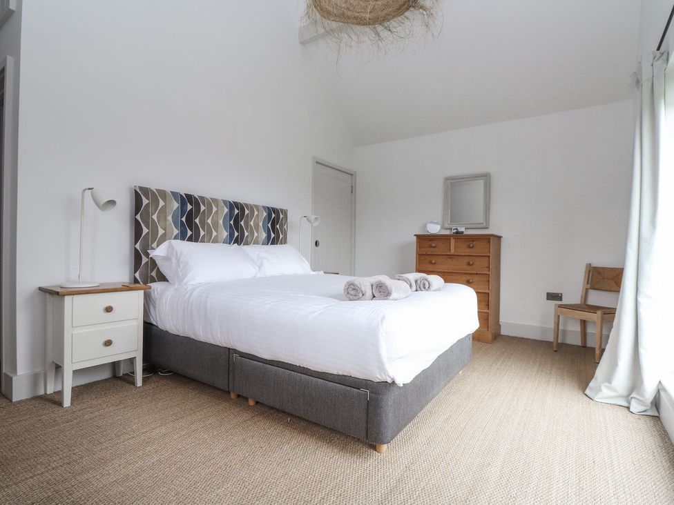 A bedroom with a bed and a dresser at Wood Meadow in Helston