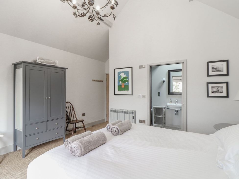 A bedroom with a bed and wardrobe at Wood Meadow in Helston