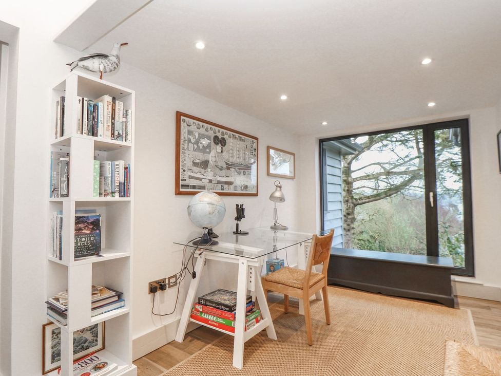 An office with a desk and bookshelf at Wood Meadow in Helston