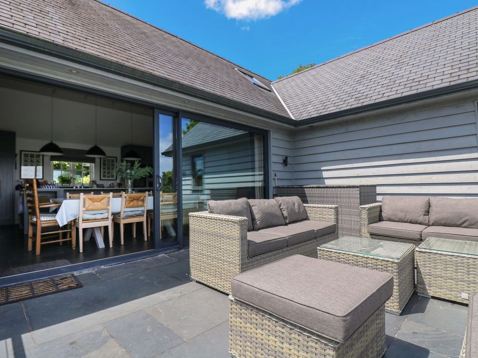 An outdoor patio with a seating area and dining table at Wood Meadow Helston