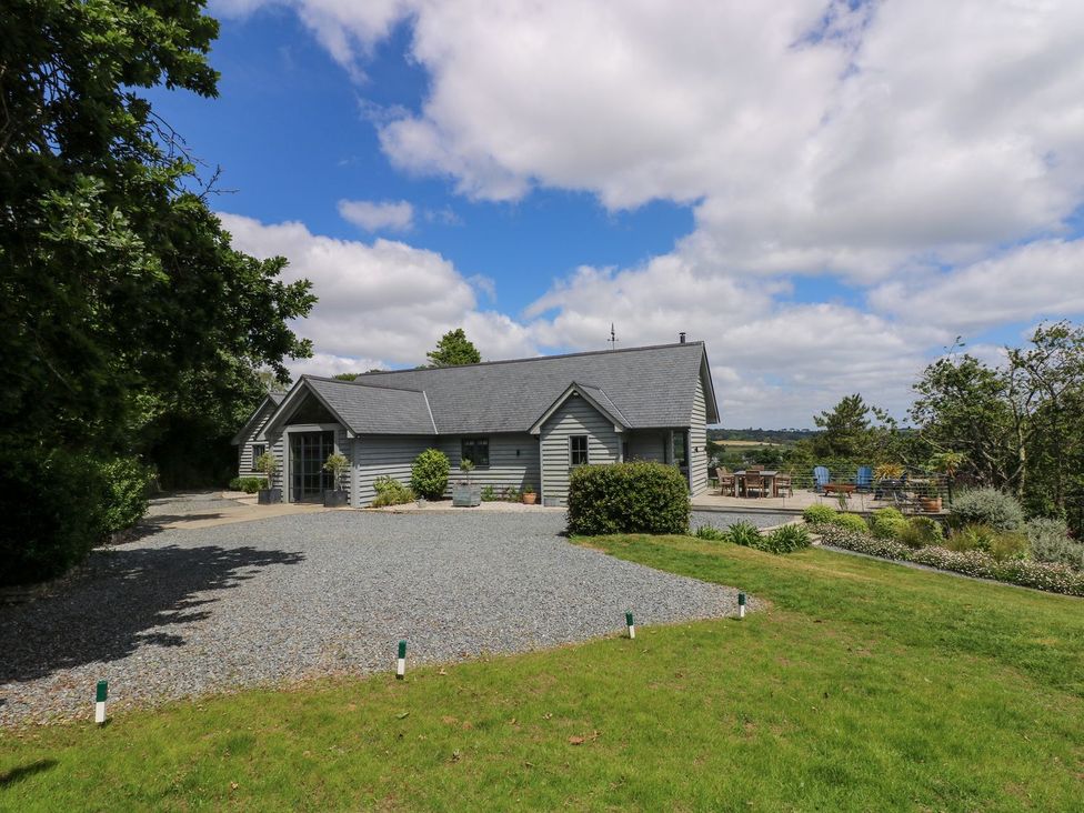 A house with a gravel driveway and garden at Wood Meadow in Helston