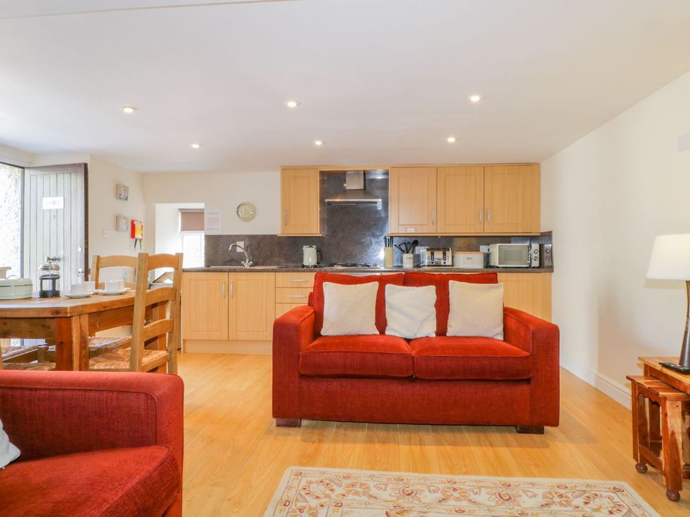 A living room with a sofa and dining table at Farmhouse Cottage in Keswick